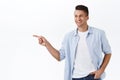 Portrait of handsome adult man pointing finger left and smiling happy, showing kid way to go, satisfied picking item in Royalty Free Stock Photo