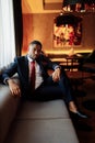 Portrait of handsome African American business male. Attractive charming man look at the camera, smiling, sitting at the