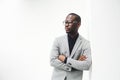 Handsome african american businessman with glasses leaning against white wall Royalty Free Stock Photo