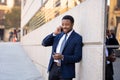 Portrait of handsome african american businessman walking in the city talking on mobile phone Royalty Free Stock Photo
