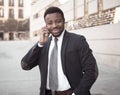 Portrait of handsome african american businessman walking in the city talking on mobile phone Royalty Free Stock Photo