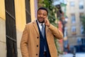 Portrait of handsome african american businessman walking in the city talking on mobile phone Royalty Free Stock Photo