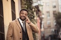 Portrait of handsome african american businessman walking in the city talking on mobile phone Royalty Free Stock Photo