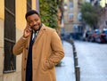 Portrait of handsome african american businessman walking in the city talking on mobile phone Royalty Free Stock Photo