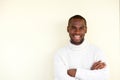 Handsome african american man smiling with arms crossed against light background Royalty Free Stock Photo