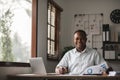 Portrait of handsome African black young business man working on laptop at office desk Royalty Free Stock Photo