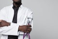 Portrait of handsome Afro American doctor with sthethoscope in white coat looking at camera, on gray background Royalty Free Stock Photo