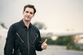 Portrait of handsome aircraft maintenance mechanic thumbs up and smiling gently in front of blurry helicopter copy space, Royalty Free Stock Photo