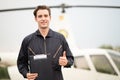 Portrait of handsome aircraft maintenance mechanic thumbs up and smiling gently in front of the helicopter as a background, Royalty Free Stock Photo