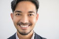 Portrait of a handsome Asian man with a beard in a gray shirt with suit making a smile face Royalty Free Stock Photo