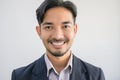 Portrait of a handsome Asian man with a beard in a gray shirt with suit making a smile face Royalty Free Stock Photo