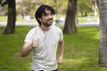 Portrait of handsome attractive mature bearded athletic latin man guy 40s in casual white t-shirt running at a park