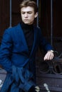 Portrait of a handsome, attractive, young man in a blue suit, coat, in the city. pensive and sad, waiting Royalty Free Stock Photo