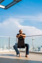 Portrait of handsome bald man sitting and thinking outdoors in city Royalty Free Stock Photo