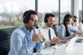 Portrait of handsome beard man with headset looking carefully at laptop while listening to customer during online chat at call Royalty Free Stock Photo