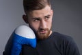 Portrait of handsome bearded brutal guy in sportswear standing in a combat pose, holding raised hands near his face, in boxing