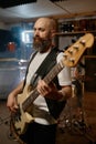 Portrait of handsome bearded guitarist of rock band playing guitar