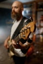 Portrait of handsome bearded guitarist of rock band playing guitar