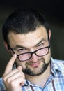 Portrait of handsome bearded intelligent modern photogenic young man in glasses with short haircut and kind black eyes smiling in