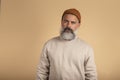 Portrait of a handsome bearded man looking seriously at the camera over beige background Royalty Free Stock Photo