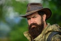 Portrait of handsome bearded man with serious face ond cowboy hat outdoor. Close up masculine face. Royalty Free Stock Photo