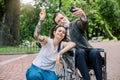 Portrait of handsome bearded senior man on wheelchair and his young hipster carer or granddaughter with tattoo and Royalty Free Stock Photo