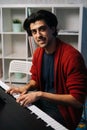 Portrait of handsome bearded young pianist man sitting at piano enjoying virtuoso music in free time. Royalty Free Stock Photo