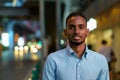 Portrait of handsome black African businessman outdoors in city at night smiling Royalty Free Stock Photo