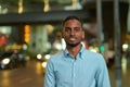 Portrait of handsome black African businessman outdoors in city at night smiling Royalty Free Stock Photo