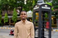 Portrait of handsome black young African businessman smiling outdoors in city Royalty Free Stock Photo