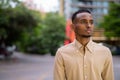 Portrait of handsome black young African businessman thinking outdoors in city Royalty Free Stock Photo