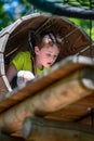 Portrait of a handsome boy on a rope park among trees. Children summer activities.