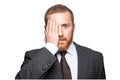 Portrait of handsome businessman covering one eye with his hand as he looks directly at the camera. Royalty Free Stock Photo