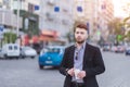 Portrait of a handsome businessman with a cup of coffee against a background of blurred urban landscape Royalty Free Stock Photo