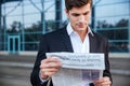 Portrait of a handsome businessman reading newspaper outdoors Royalty Free Stock Photo