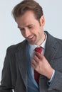 Portrait of a handsome businessman smiling, fixing his tie Royalty Free Stock Photo