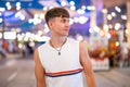 Portrait of handsome caucasian young guy wearing sleeveless t-shirt posing on the city street at night. Royalty Free Stock Photo