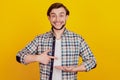 Portrait of handsome cheerful funky guy point fonger promo product offer isolated over bright yellow color background