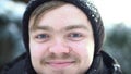 Portrait of handsome, cheerful man with moustache dressed in winter clothes with snow on his face. Close up for blond Royalty Free Stock Photo