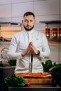 Portrait of handsome chef cooking raw meat in the kitchen. ÃÂ¡hef holds a professional kitchen knife. Concept of Cooking process Royalty Free Stock Photo