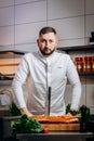 Portrait of handsome chef cooking raw meat in the kitchen. ÃÂ¡hef holds a professional kitchen knife. Concept of Cooking process Royalty Free Stock Photo