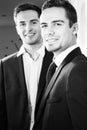 Portrait of handsome couple of men wearing suits smiling at camera