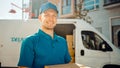 Portrait of Handsome Delivery Man Holds Cardboard Box Package Standing in Modern Stylish Business Royalty Free Stock Photo