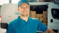 Portrait of Handsome Delivery Man Holds Cardboard Box Package Standing in Modern Stylish Business Royalty Free Stock Photo