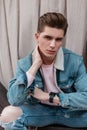 Portrait handsome European young man with trendy hairstyle in stylish denim blue jacket with white collar posing outdoors summer Royalty Free Stock Photo