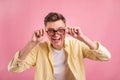 Portrait of handsome excited man in glasses and in basic clothing smiling and showing ok sign at camera Royalty Free Stock Photo