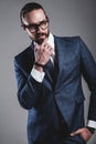 Handsome fashion businessman dressed in elegant blue suit on gray background