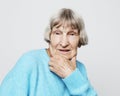 Portrait of handsome grandmother in blue sweater. Dreaming, wondering concept