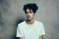 portrait of a handsome guy with curly hair on a gray background white t-shirt close-up model Royalty Free Stock Photo