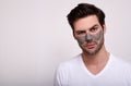 Portrait of a handsome guy in a white t-shirt in a cosmetic face mask Royalty Free Stock Photo